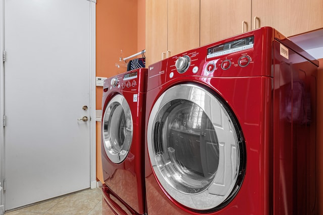 washroom featuring cabinet space, separate washer and dryer, and light tile patterned flooring