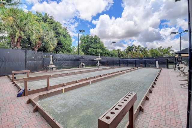 view of home's community featuring a bocce ball area and fence