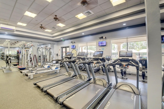 gym featuring an AC wall unit, a drop ceiling, crown molding, and ceiling fan