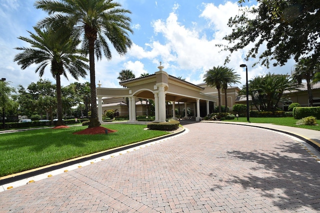 view of property's community featuring curved driveway and a lawn
