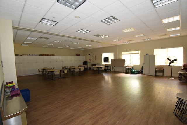 interior space with a drop ceiling and dark hardwood / wood-style flooring