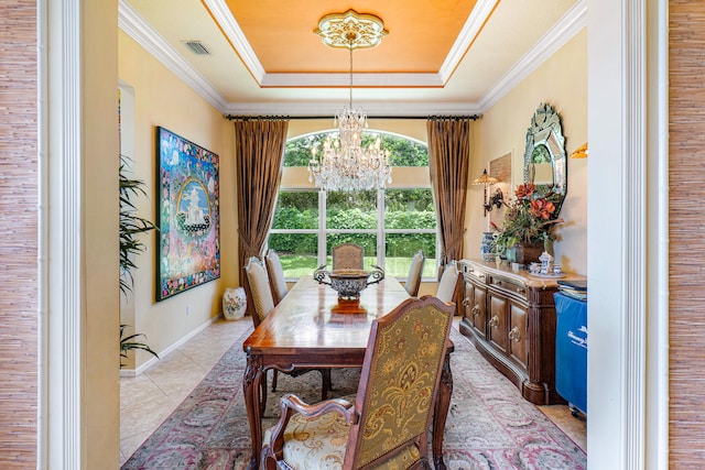 tiled dining room with a notable chandelier, ornamental molding, and a raised ceiling