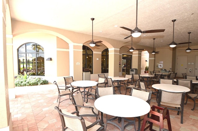 dining space featuring a ceiling fan and arched walkways