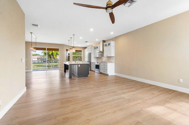 unfurnished living room with light wood-type flooring and ceiling fan