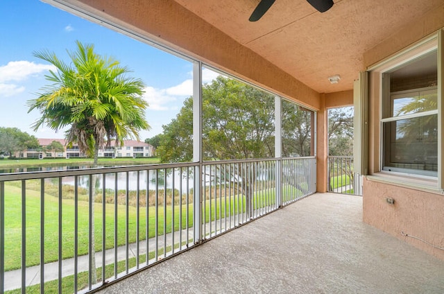 unfurnished sunroom with a water view and ceiling fan