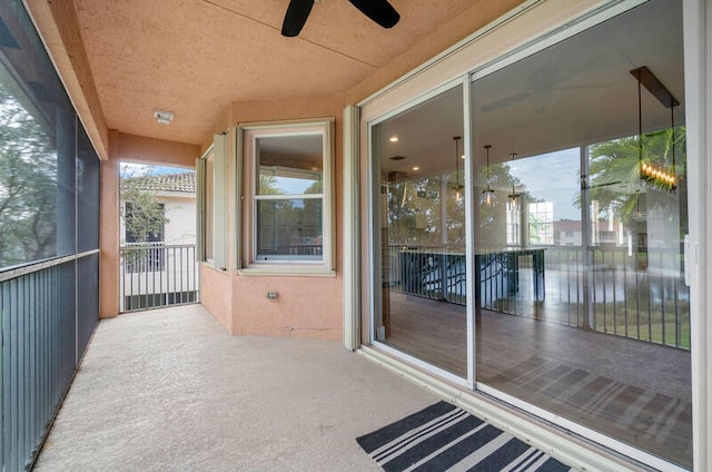 unfurnished sunroom featuring ceiling fan