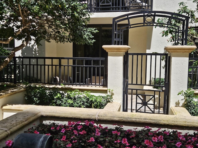 exterior space featuring a balcony, a gate, and fence