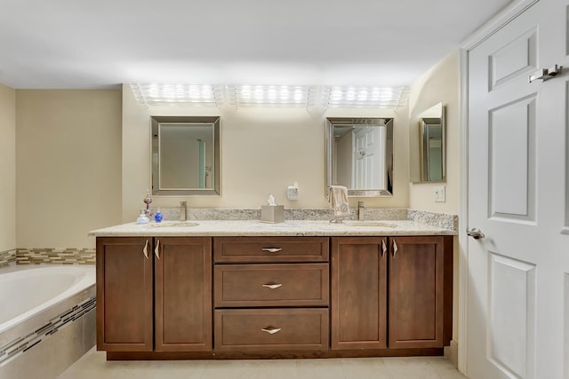 bathroom with vanity, tiled tub, and tile patterned flooring