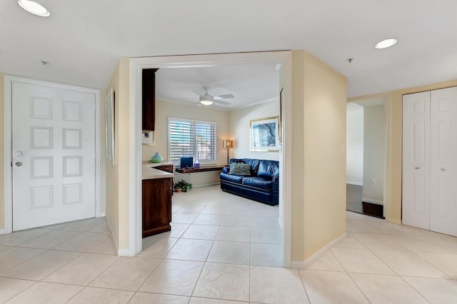 corridor featuring ornamental molding and light tile patterned floors