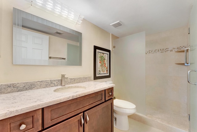 bathroom with vanity, a shower with shower door, and toilet