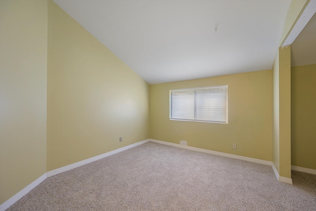 unfurnished room with carpet floors and vaulted ceiling