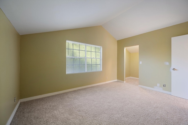 carpeted empty room with lofted ceiling