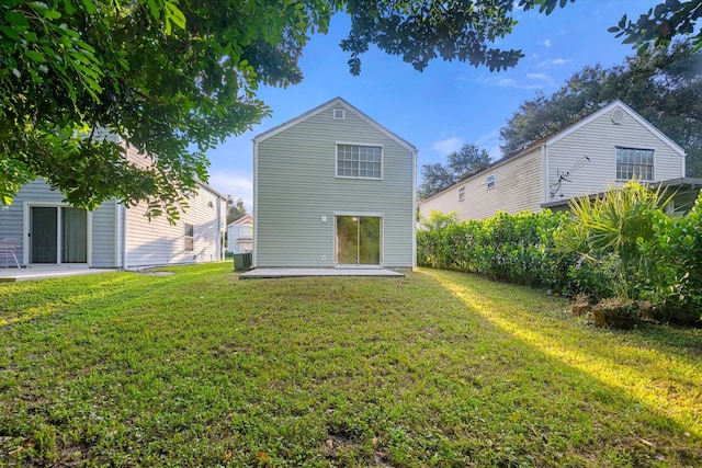 rear view of property featuring a patio and a lawn