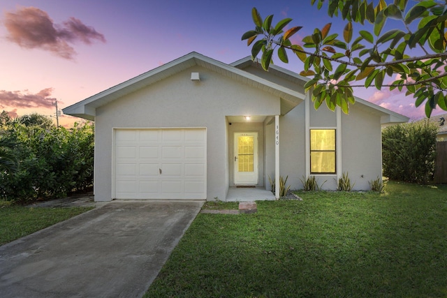 ranch-style home featuring a lawn and a garage