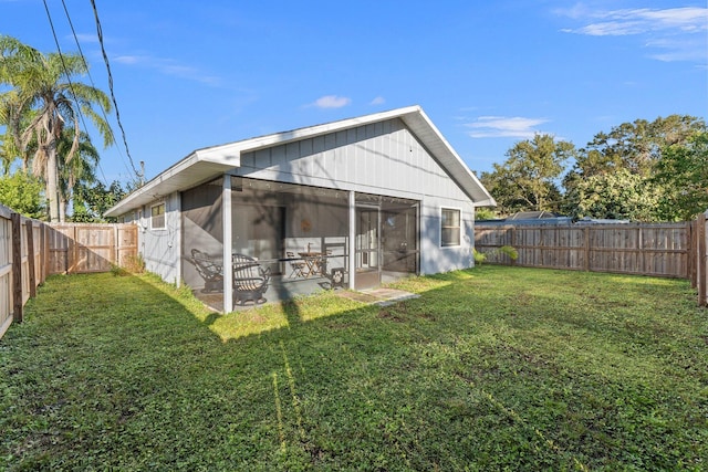 back of house featuring a lawn and a sunroom