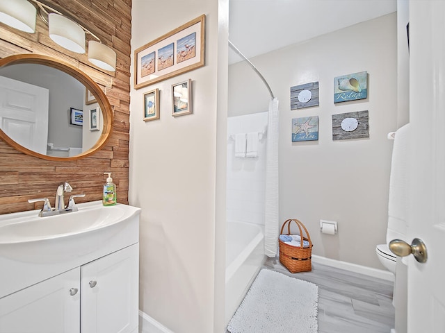 full bathroom featuring hardwood / wood-style flooring, toilet, wood walls, vanity, and shower / tub combo with curtain