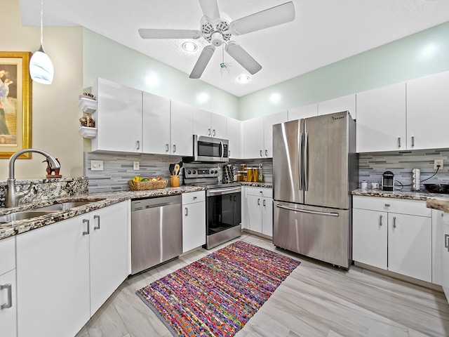 kitchen featuring appliances with stainless steel finishes, sink, decorative backsplash, and white cabinets