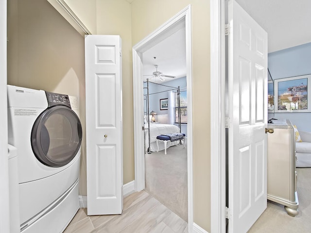 laundry room with light carpet and ceiling fan