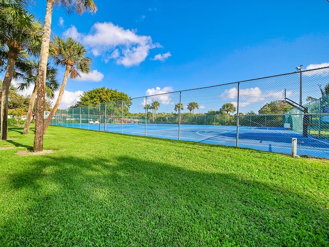 view of tennis court with a lawn