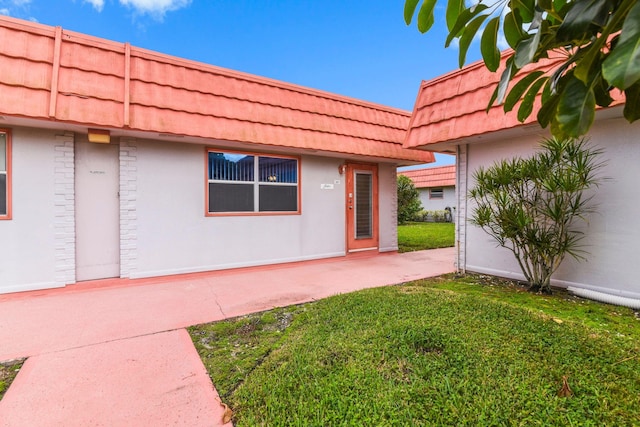 doorway to property with a yard