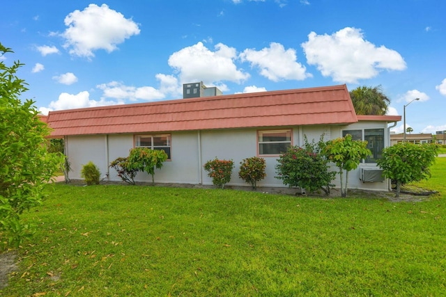 view of home's exterior with central AC and a yard