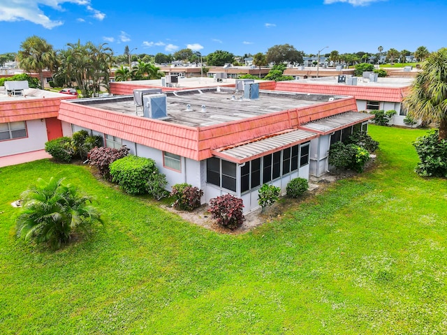 rear view of property featuring a yard and a sunroom