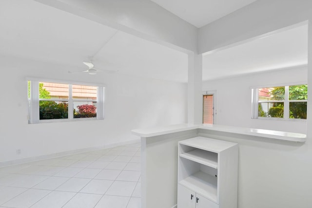 interior space with light tile patterned floors, a wealth of natural light, and ceiling fan