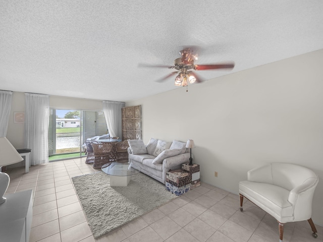 tiled living room with a textured ceiling and ceiling fan