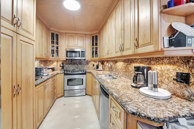 kitchen featuring light brown cabinets, light stone countertops, stainless steel appliances, and sink