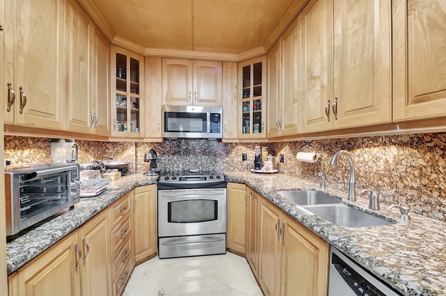 kitchen featuring decorative backsplash, appliances with stainless steel finishes, light stone countertops, light brown cabinetry, and sink