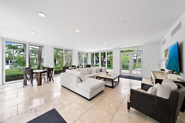 living room with a wall of windows and french doors