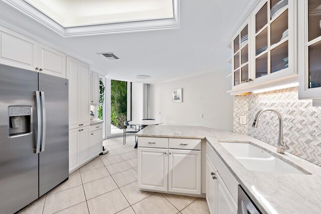 kitchen with white cabinets, sink, appliances with stainless steel finishes, tasteful backsplash, and light tile patterned flooring