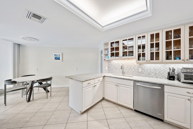 kitchen featuring sink, light tile patterned floors, stainless steel dishwasher, backsplash, and white cabinets