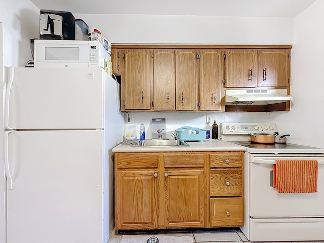 kitchen with white appliances, light tile patterned floors, and sink