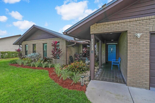 view of exterior entry featuring a lawn and a garage