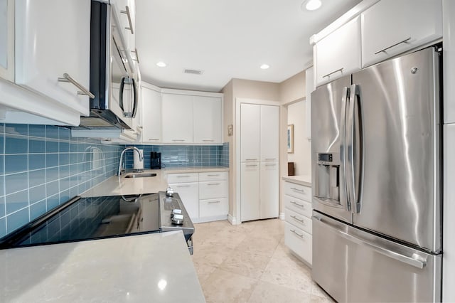 kitchen with decorative backsplash, appliances with stainless steel finishes, white cabinetry, and sink