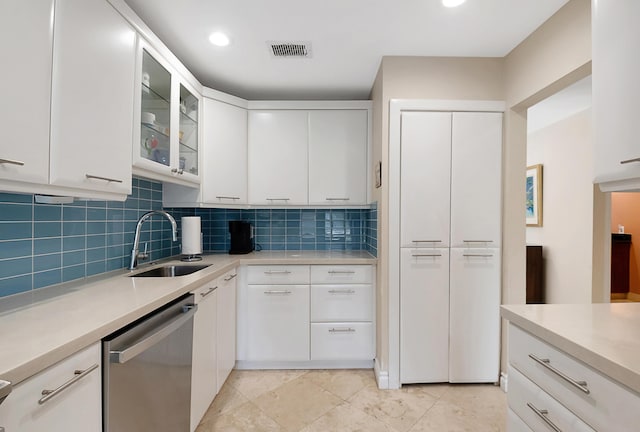 kitchen featuring dishwasher, backsplash, white cabinetry, and sink