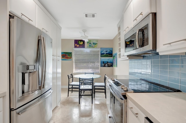 kitchen with backsplash, white cabinetry, ceiling fan, and stainless steel appliances