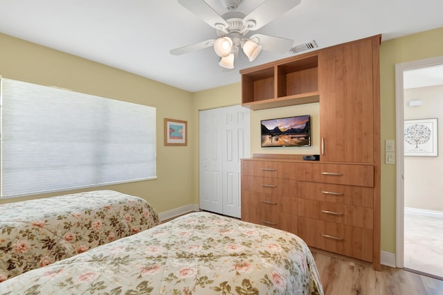 bedroom featuring ceiling fan, light wood-type flooring, and a closet