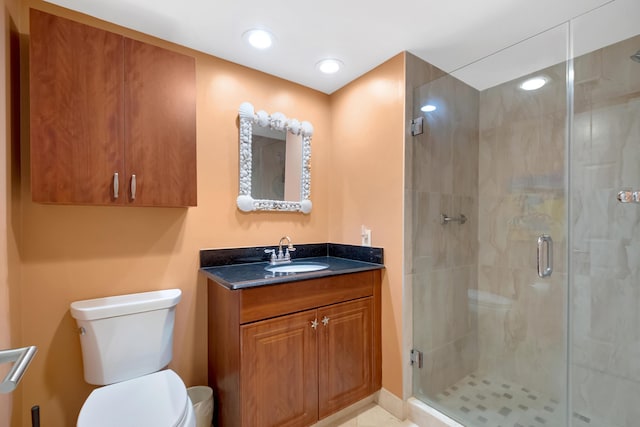 bathroom featuring vanity, toilet, and a shower with shower door