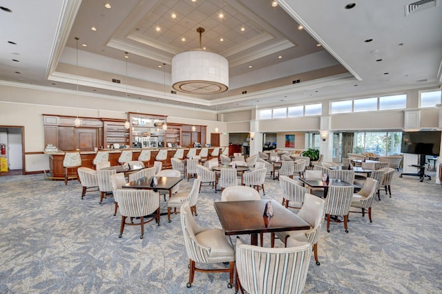 dining space featuring a tray ceiling, carpet, a high ceiling, and ornamental molding