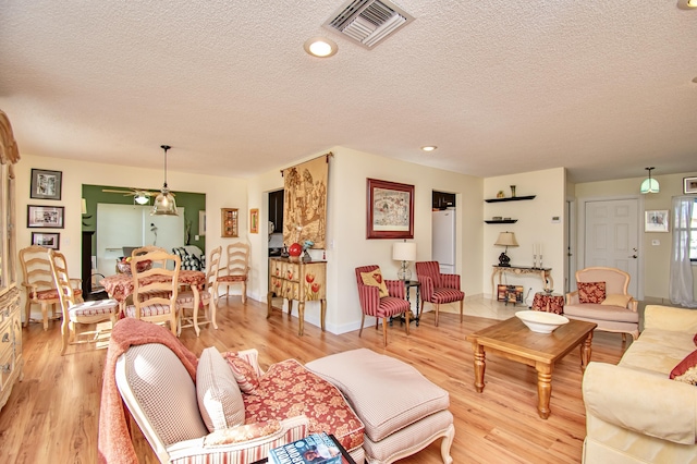 6357 Stanley Ln, Delray Beach, FL 33484 - living room featuring light wood finished floors, a textured ceiling, ceiling fan, and baseboards