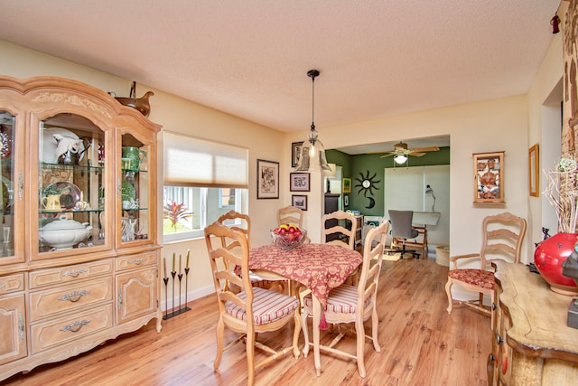 dining space featuring a textured ceiling, light hardwood / wood-style floors, and ceiling fan