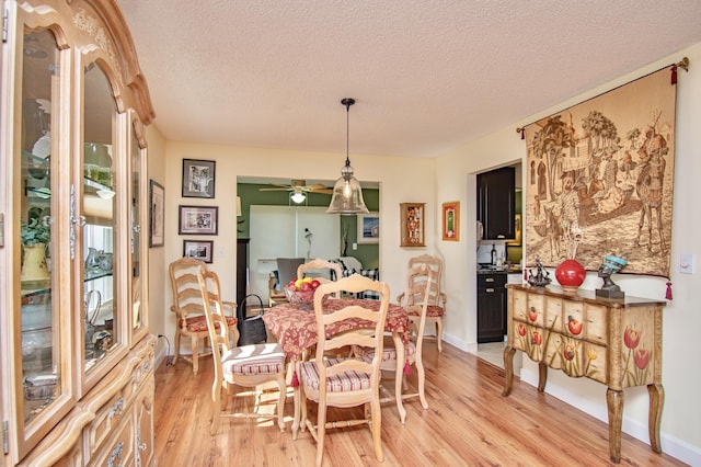 6357 Stanley Ln, Delray Beach, FL 33484 - dining area featuring light wood-style flooring, a textured ceiling, ceiling fan, and baseboards