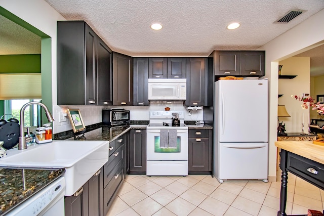 kitchen featuring sink, tasteful backsplash, white appliances, and light tile patterned floors