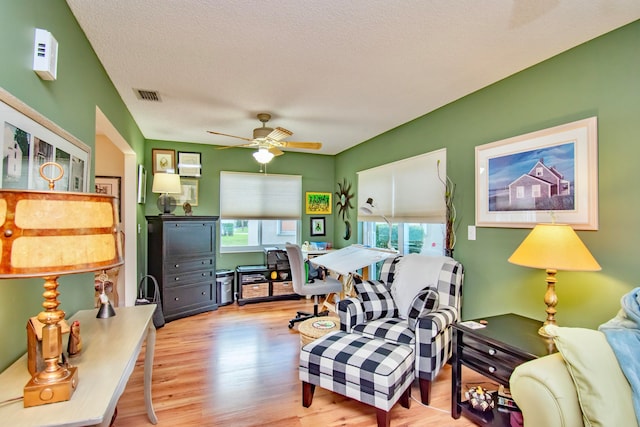 interior space featuring a textured ceiling, light wood-type flooring, and ceiling fan