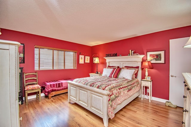 bedroom with light hardwood / wood-style flooring and a textured ceiling