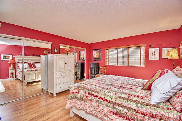 bedroom with light hardwood / wood-style flooring and a textured ceiling