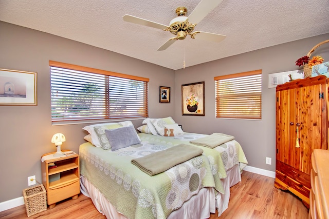 bedroom featuring a textured ceiling, light wood-type flooring, and ceiling fan