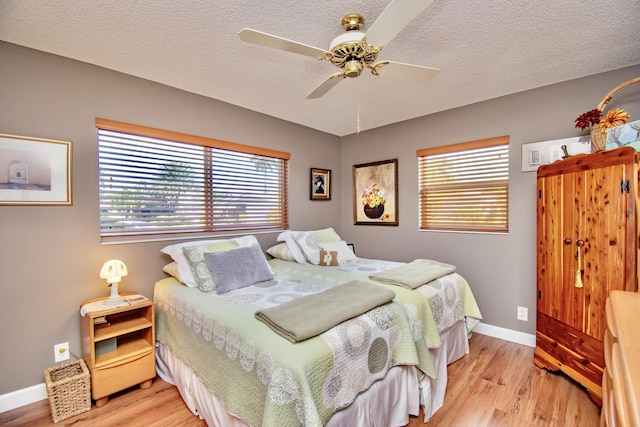 6357 Stanley Ln, Delray Beach, FL 33484 - bedroom featuring multiple windows, light wood finished floors, baseboards, a textured ceiling, and ceiling fan